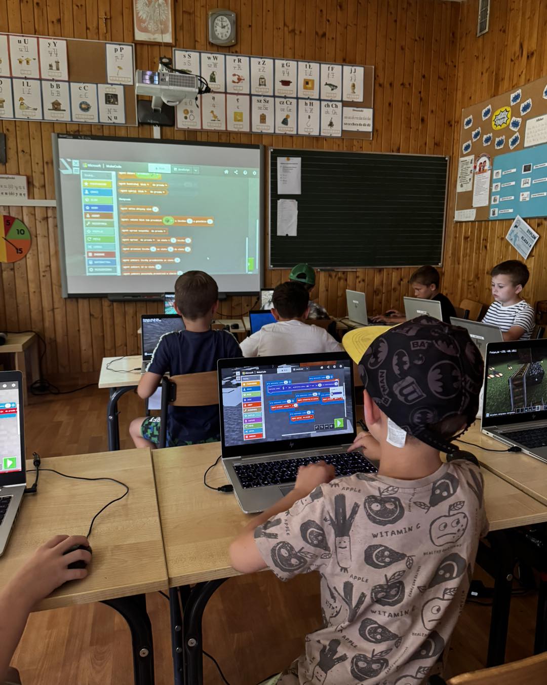 Dzieci programujące przy komputerach podczas zajęć